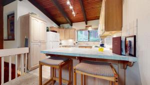 a kitchen with a counter with stools in it at Mammoth West #101 Condo in Mammoth Lakes +26 photos