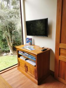 un centro de entretenimiento de madera con TV en la pared en Misty River Retreat, en Blenheim