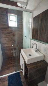 een badkamer met wastafel en douche met spiegel bij Marco Zero Containers 2 in Balneário Camboriú +11 foto's