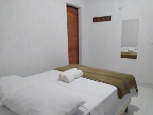 a bedroom with a white bed with a towel on it at Pousada Águas da Chapada in Carolina