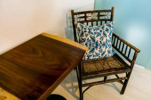 poduszkę siedzącą na krześle obok drewnianego stołu w obiekcie Numero Uno Beach House w mieście San Juan