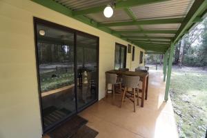 Karriwood Cottage في بيمبرتون: شرفة مشرفة للمنزل مع طاولة وكراسي +6 صور