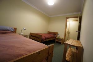 a bedroom with two beds and a table in it at Karriwood Cottage in Pemberton