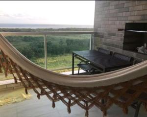 a hammock on a balcony with a table and a view at SALINAS PARK RESORT in Salinópolis