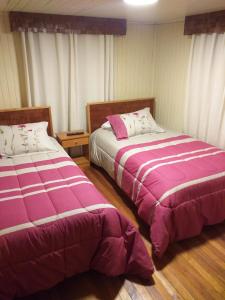 dos camas sentadas una al lado de la otra en un dormitorio en Refugio Insular, en Castro