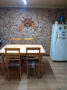 mesa de cocina con 2 sillas y nevera blanca en Refugio Insular, en Castro 6 fotos más