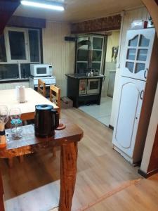 een keuken met een tafel, een fornuis en een koelkast bij Refugio Insular in Castro