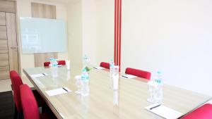 einen Konferenzraum mit einem langen Tisch und roten Stühlen in der Unterkunft Moritz Hotel RSAB Harapan Kita in Jakarta