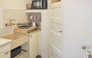 una pequeña cocina con fregadero y microondas en Duinviooltje 2, en Bergen aan Zee