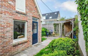 Casa de ladrillo con puerta azul y patio en Duinviooltje 2, en Bergen aan Zee