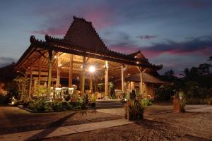 a large wooden pavilion with a roof at night at Bhumi Kasuryan Borobudur in Borobudur