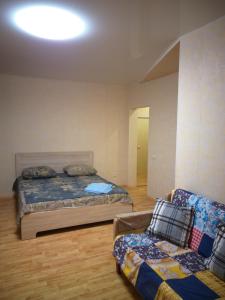 ニジニ・タギルにあるApartamenty Na Prospekte Stroiteleyのベッドルーム(ベッド1台、ソファ付)