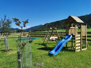 einen Spielplatz mit Rutsche und Schaukel in der Unterkunft Gut Römerhof in Altenmarkt im Pongau