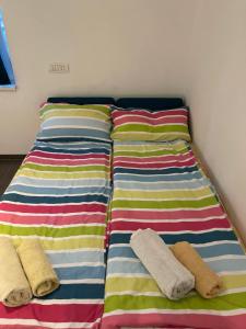 ドロベタ・トゥルヌ・セヴェリンにあるSmall Single Roomのカラフルなストライプシーツが備わる客室のベッド2台