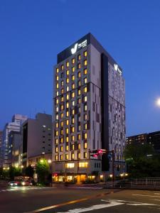 un edificio alto en una calle de la ciudad por la noche en Far East Village Hotel Yokohama, en Yokohama