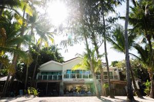 een gebouw op het strand met palmbomen bij Villa Caemilla Beach Boutique Hotel in Boracay