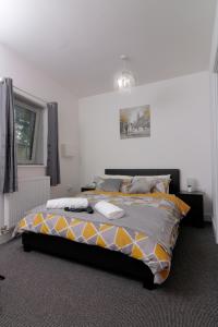 a bedroom with a bed with a yellow and gray comforter at Canal View Apartment in Bletchley
