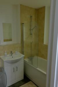a bathroom with a sink and a shower and a tub at Canal View Apartment in Bletchley