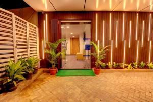 a lobby with potted plants and an open door at MySpace Express GD Inn in Bangalore