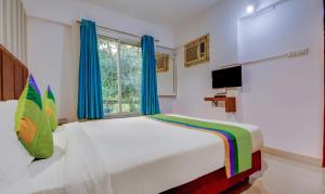 Postel nebo postele na pokoji v ubytování Treebo Iris Suites