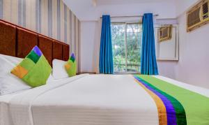 Postel nebo postele na pokoji v ubytování Treebo Iris Suites