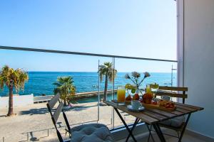 a table on a balcony with a view of the ocean at Phaedrus Living: Seaview Onyx Flat Lighthouse 48 in Paphos
