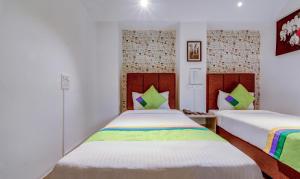 Postel nebo postele na pokoji v ubytování Treebo Iris Suites
