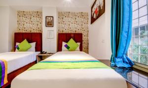 Postel nebo postele na pokoji v ubytování Treebo Iris Suites
