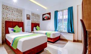 Postel nebo postele na pokoji v ubytování Treebo Iris Suites