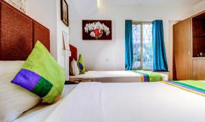 Postel nebo postele na pokoji v ubytování Treebo Iris Suites
