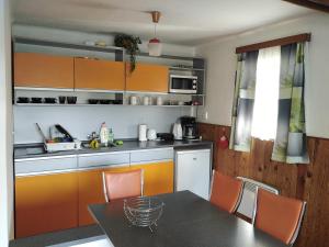 a kitchen with orange cabinets and a table with chairs at Cottage IRENA in Giant Mountains in Černý Dŭl