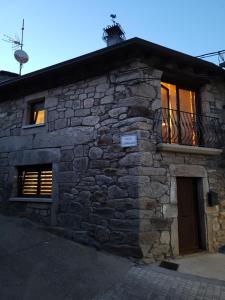 a stone building with a door and a balcony at La Cantina in Chanos