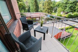 un balcone con sedie, tavolo e strada di Apartament City Center Classic - Luxury Standard a Krynica-Zdrój