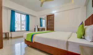 Postel nebo postele na pokoji v ubytování Treebo Iris Suites