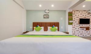 Postel nebo postele na pokoji v ubytování Treebo Iris Suites