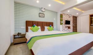 Postel nebo postele na pokoji v ubytování Treebo Iris Suites