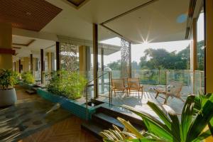 a house with glass walls and potted plants at The Botanica Sanctuary in Puncak