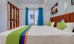 Postel nebo postele na pokoji v ubytování Treebo Iris Suites
