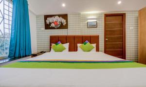 Postel nebo postele na pokoji v ubytování Treebo Iris Suites