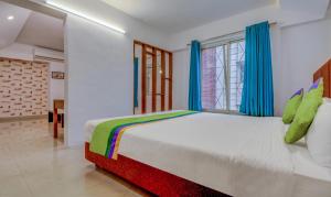Postel nebo postele na pokoji v ubytování Treebo Iris Suites