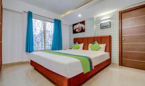 Postel nebo postele na pokoji v ubytování Treebo Iris Suites