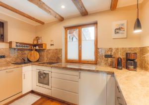 a kitchen with white cabinets and a window at Appartement Aschbach in Kitzbühel