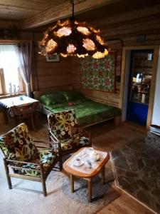 a room with a table and chairs and a chandelier at Caputówka 100 letnia chata in Rajcza