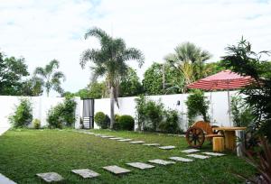 een tuin met een bank en een parasol bij Casareal Hotel by Cocotel in Concepcion
