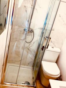 a shower with a glass door next to a toilet at Finca El Miruéndano in La Franca