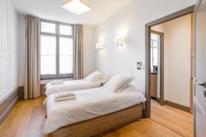 two beds in a room with a mirror at Résidence de Tourisme Central Parc Tours in Tours