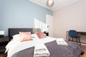 a bedroom with a large bed with towels on it at City of the Kings - Indigo Apartment in Krakow