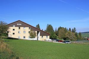 a large building with a grass field in front of it at Azureva Métabief in Métabief