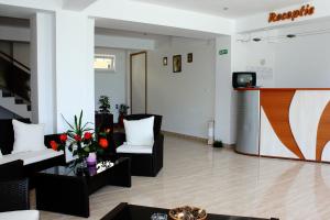 Sala de estar con 2 sillas blancas y TV en Vila Bucura 19, en Venus