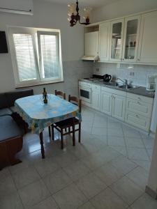 a kitchen with a table and chairs and a sink at Apartment in Lopar with sea view, terrace, air conditioning, Wi-Fi (4618-2) in Lopar